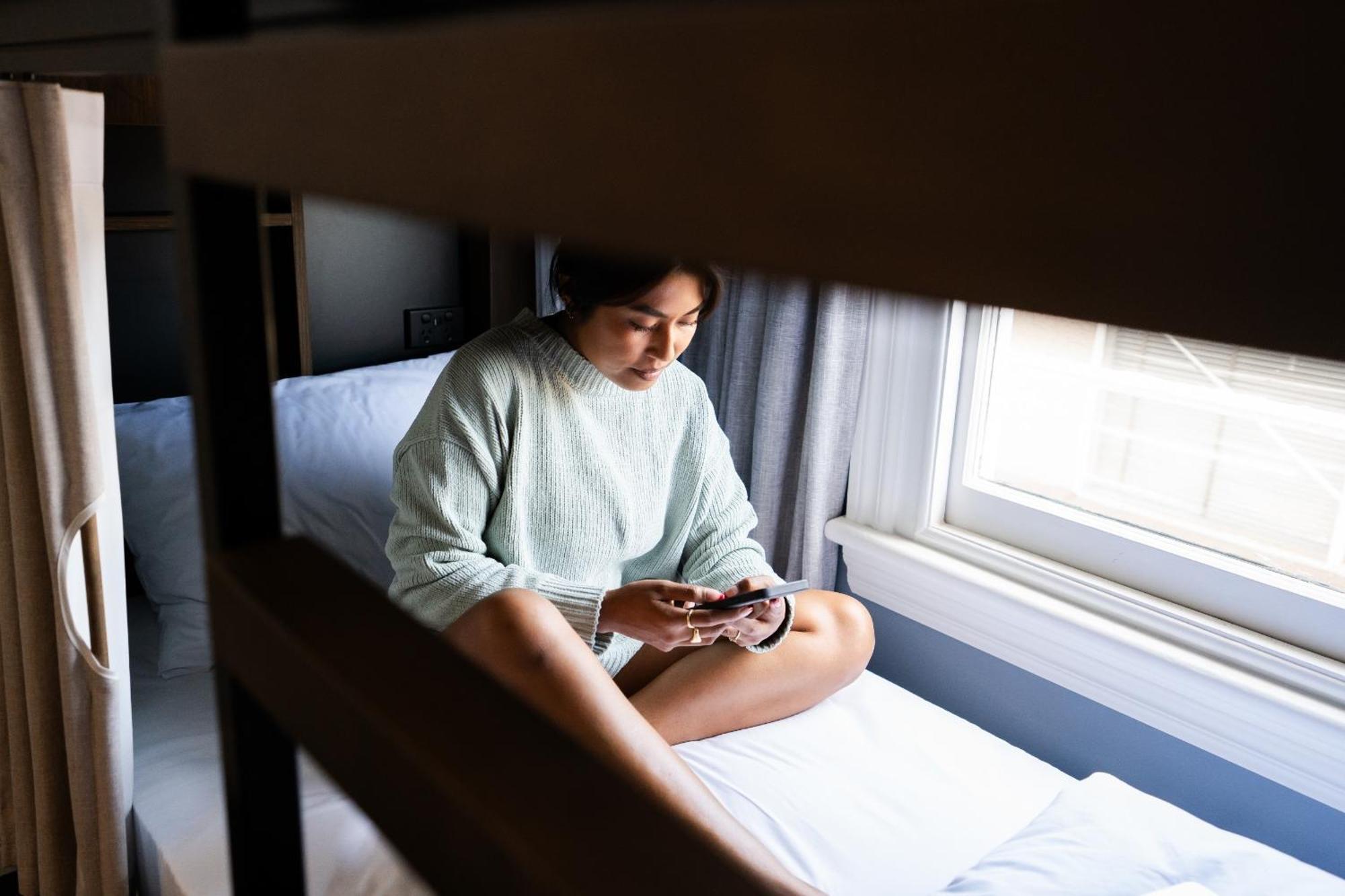 Haka House Крайстчърч Стая снимка A woman sitting on a bunk bed